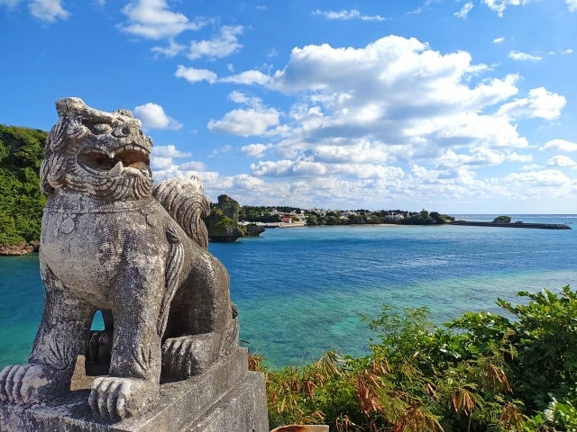 沖縄の海沿いにたたずむシーサー像
