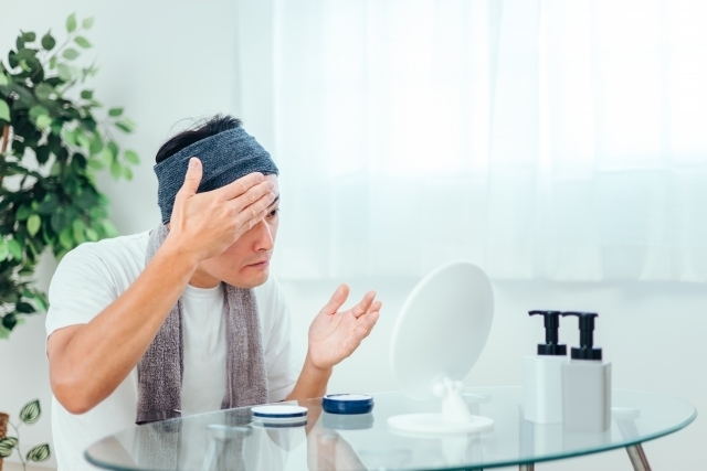 顔にクリームを塗り身だしなみを整える男性