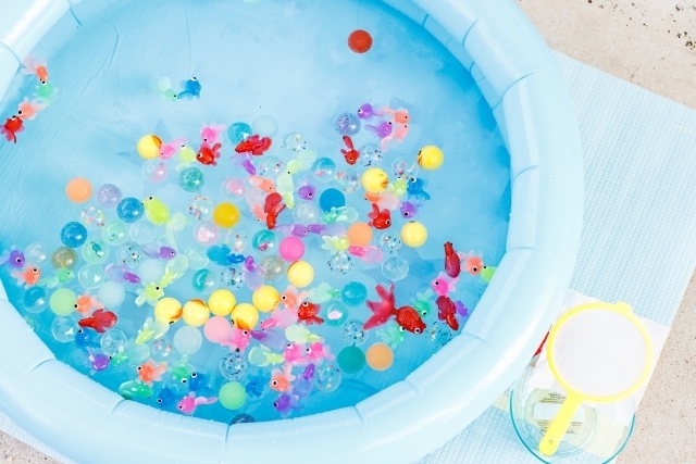 ビニールプールの中で浮いている金魚のおもちゃやボール
