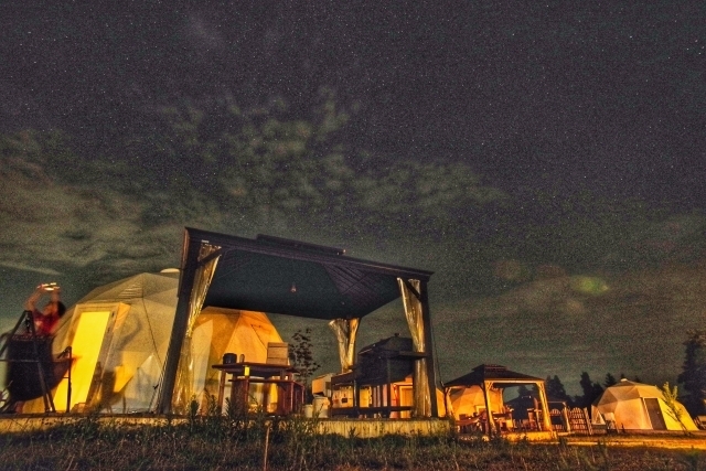 夜のグランピング場のドーム型テント